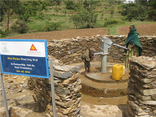 A young man drinks from one of the new drinking water wells. Source: A Glimmer of Hope