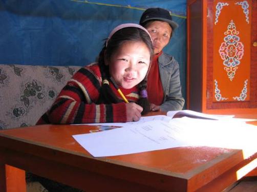 A young woman does her homework in the ger. Source: Christina Noble Children’s Foundation