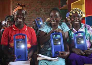 Un grupo de mujeres muestra sus nuevas radios. Fuente: Lifeline Energy