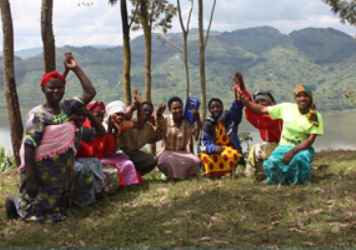 Un grupo de mujeres al aire libre alrededor de una radio. Fuente: Lifeline Energy