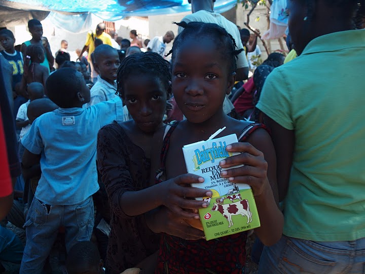 Two young beneficiaries with a milk carton. Source: Our Little Brothers Foundation