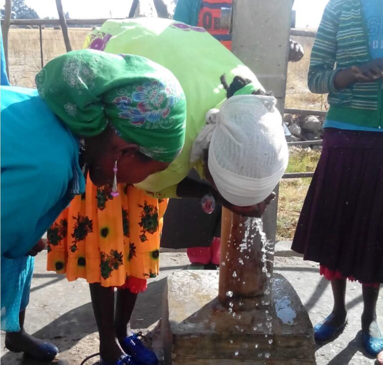 Woman drinking clean water from a well. Source: A Glimmer of Hope