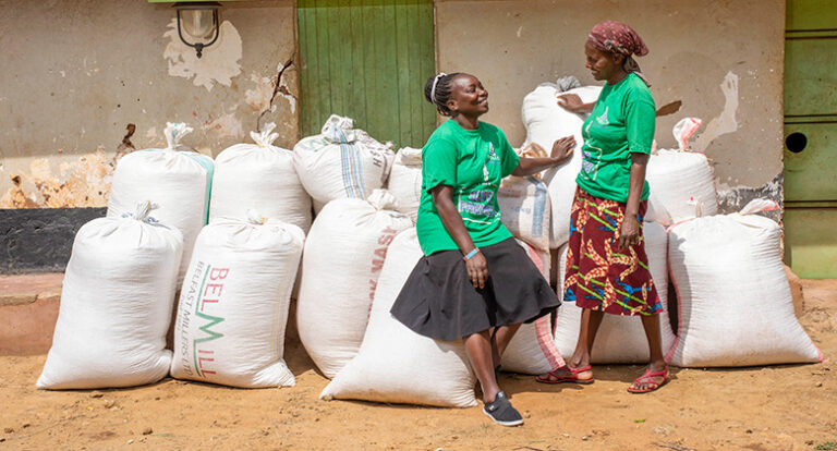 Beneficiaries in front of their harvest. Source: Apollo Agriculture.