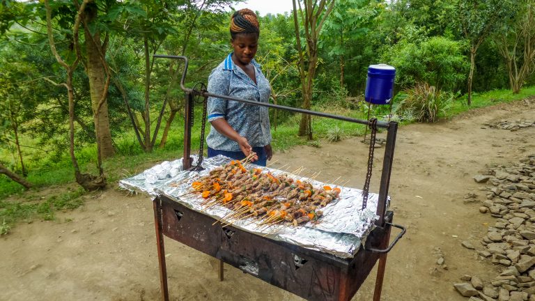 Mujer cocinando pinchos para su venta a turistas. Fuente: Almazoff