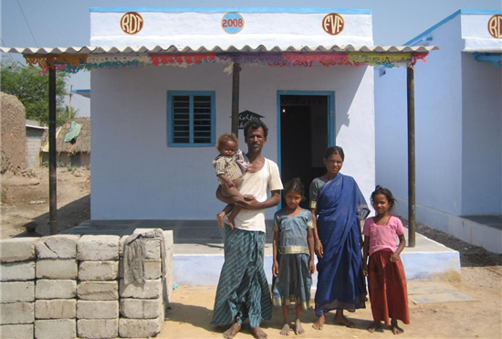 Una familia posa ante su casa recién construida. Fuente: Fundación Vicente Ferrer