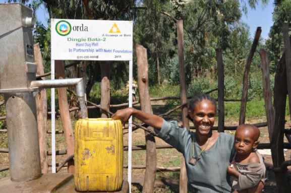 Una mujer con su hijo, satisfechos por el acceso al agua potable. Fuente: A Glimmer of Hope