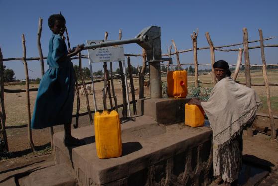 Dos mujeres llenan bidones con agua potable del pozo. Fuente: A Glimmer of Hope