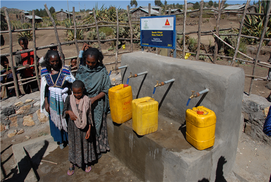 Una familia llena sus bidones de agua potable. Fuente: A Glimmer of Hope