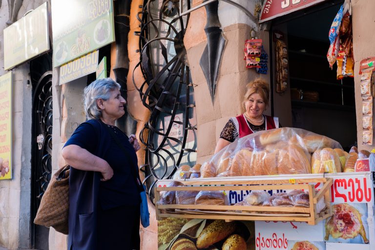 Dueña de una tienda de alimentos hablando con su clienta. Fuente: Savanevich Viktar