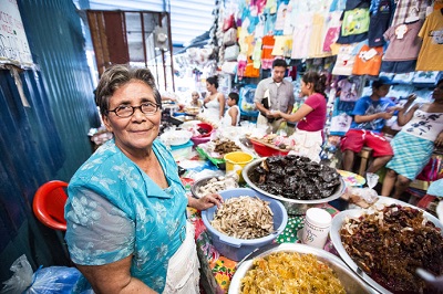 Mujer vendiendo sus postres. Fuente: FAMA