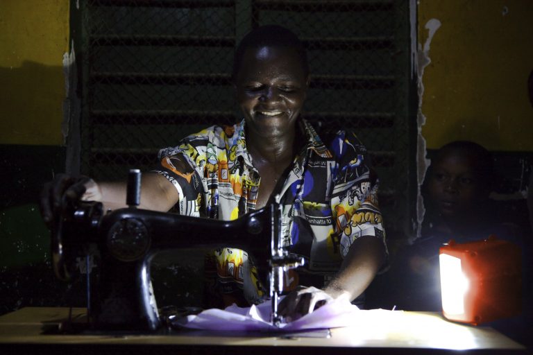 Hombre en Tanzania trabajando en su taller usando la luz de d.light. Fuente: d.light