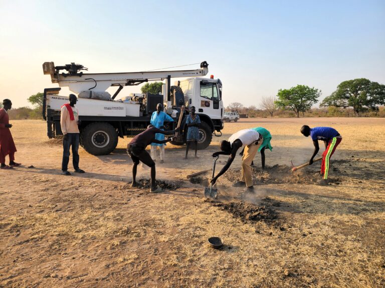 Miembros de la comunidad ayudan a preparar el terreno para la perforación. Fuente: Water for South Sudan
