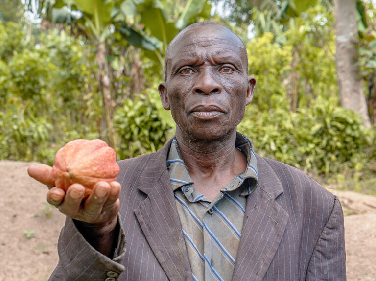 Agricultor sosteniendo cacao. Fuente: Latitude