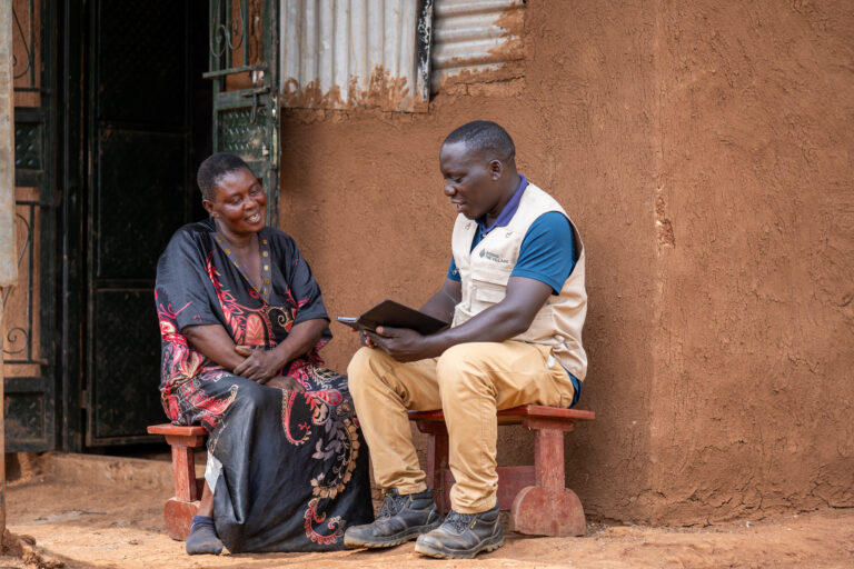 Personal de la comunidad junto a una clienta. Fuente: Raising the Village